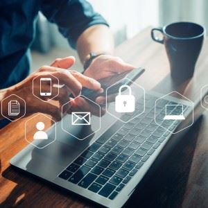 Person som bruker en telefon og en laptop